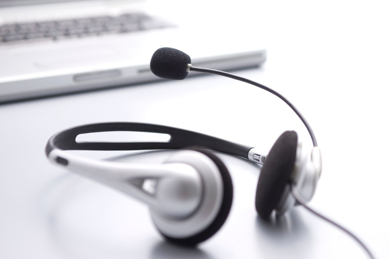 Symbolbild für sonstige arbeitsmedizinische Leistungen – Headset vor Laptop